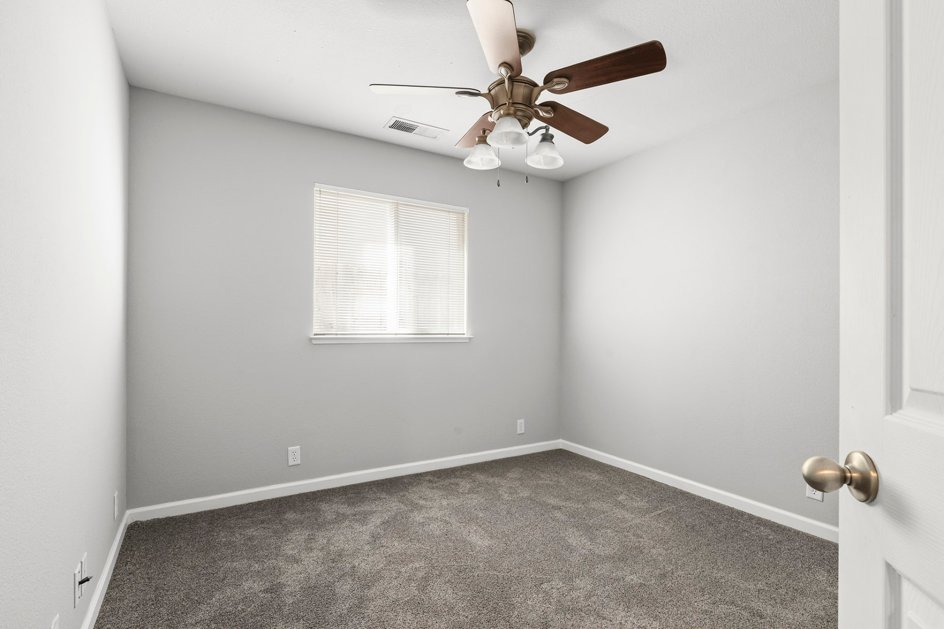 Third bedroom with ceiling fan and window