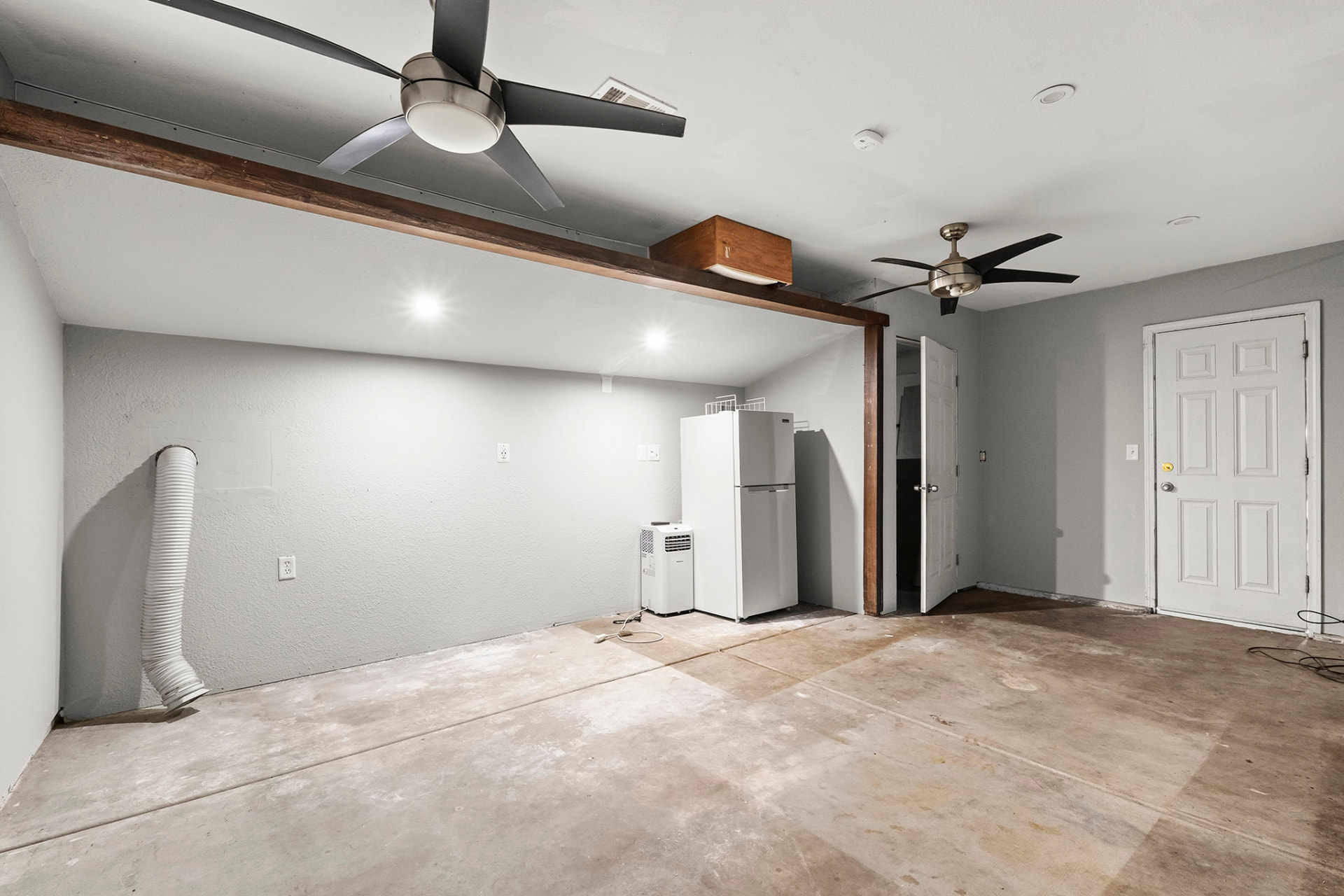 Finished garage bonus room with drywall, ceiling fans, and recessed lighting