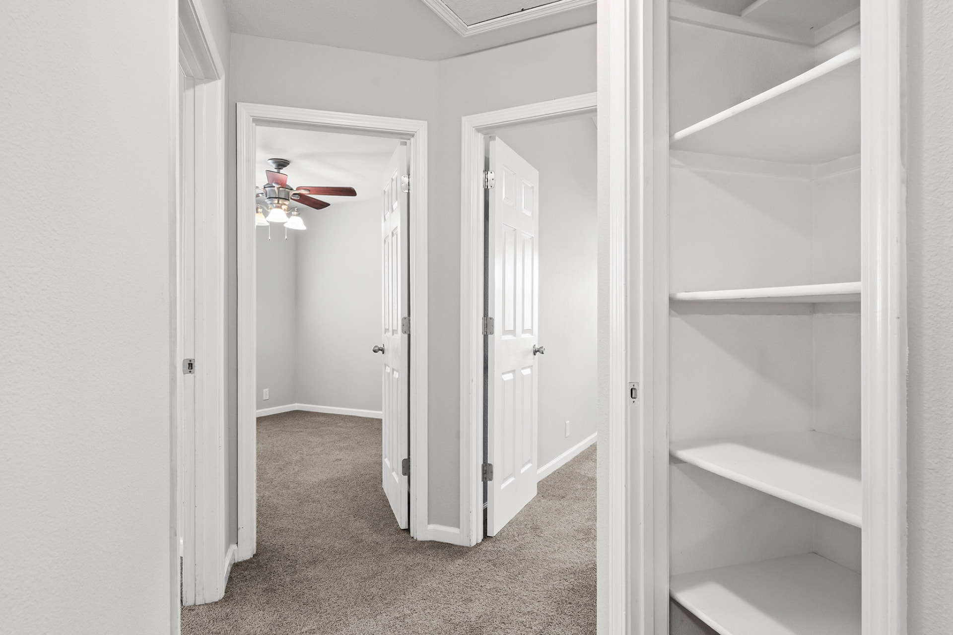 Hallway with built-in linen shelving between the bedrooms