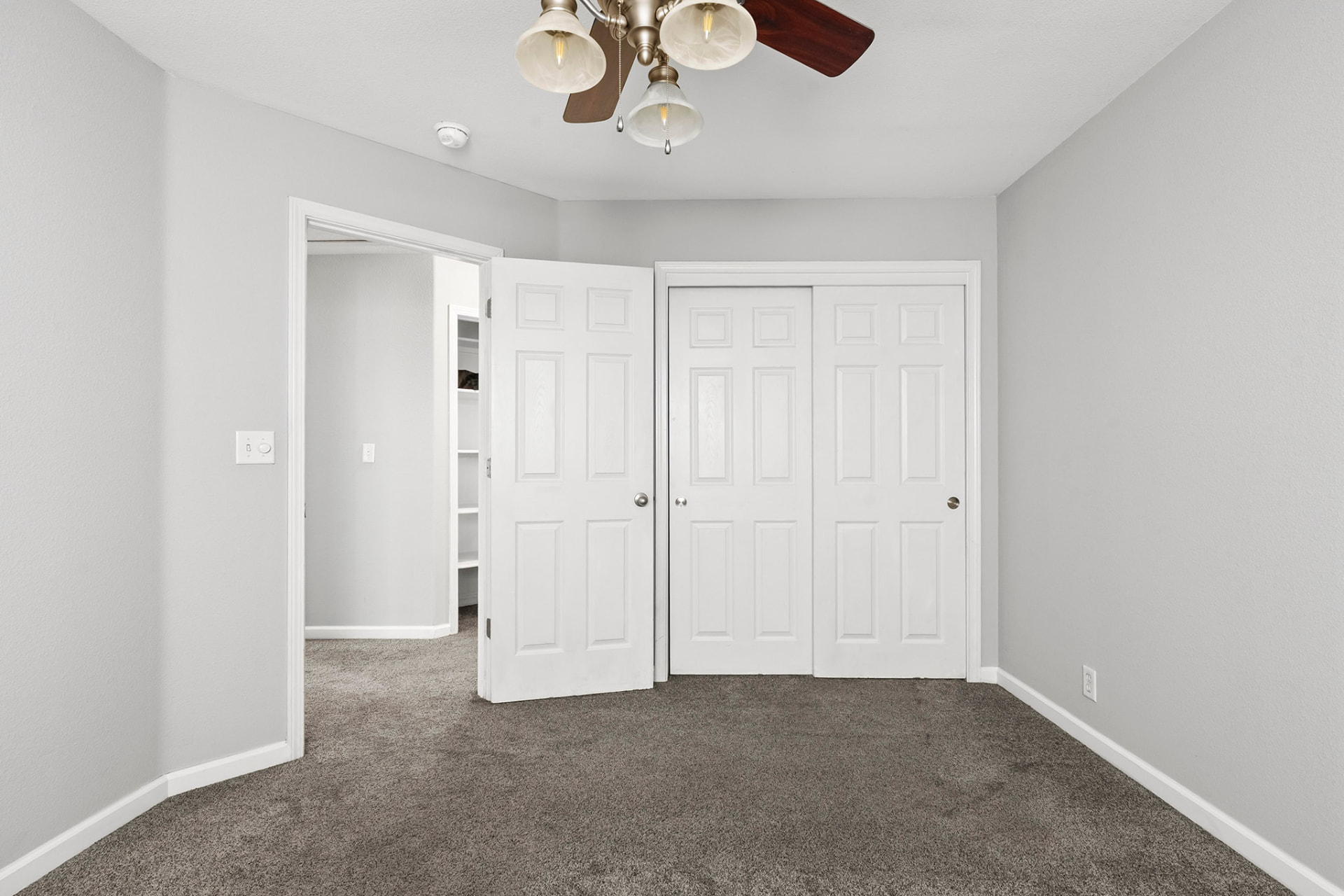 Second bedroom with ceiling fan and closet